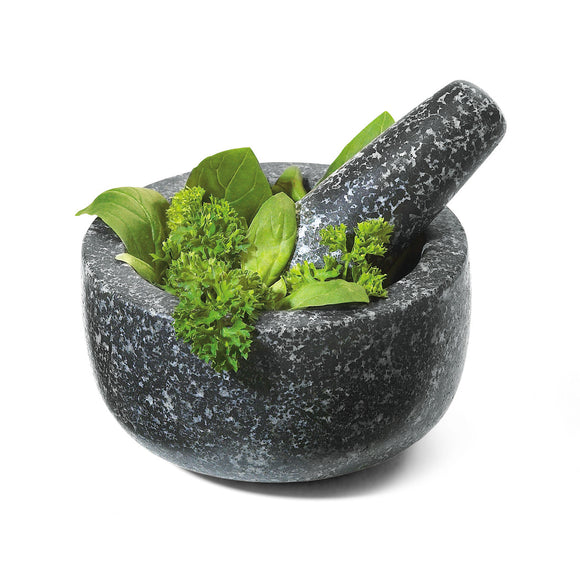 blakc and white mortar and pestle with herbs in it.